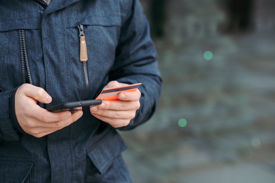 Person with mobile phone and bank card