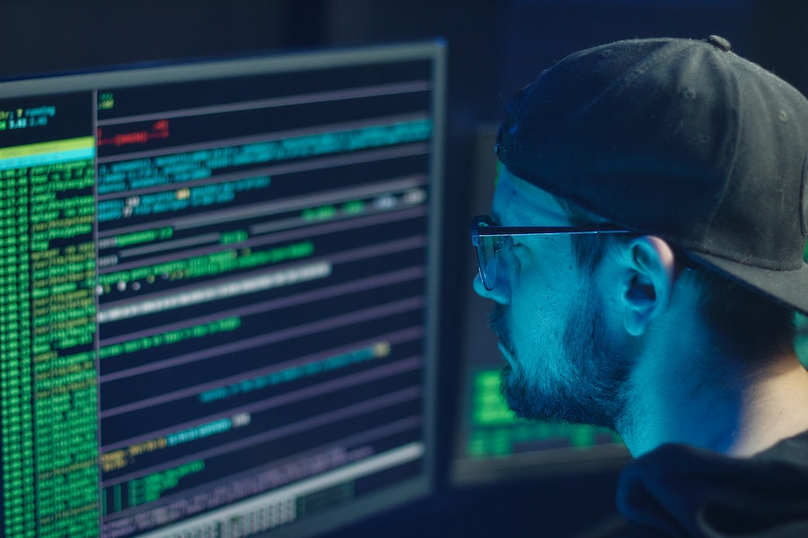 Man in cap looking at computer code