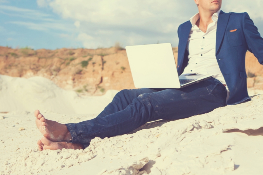 man on beach with laptop